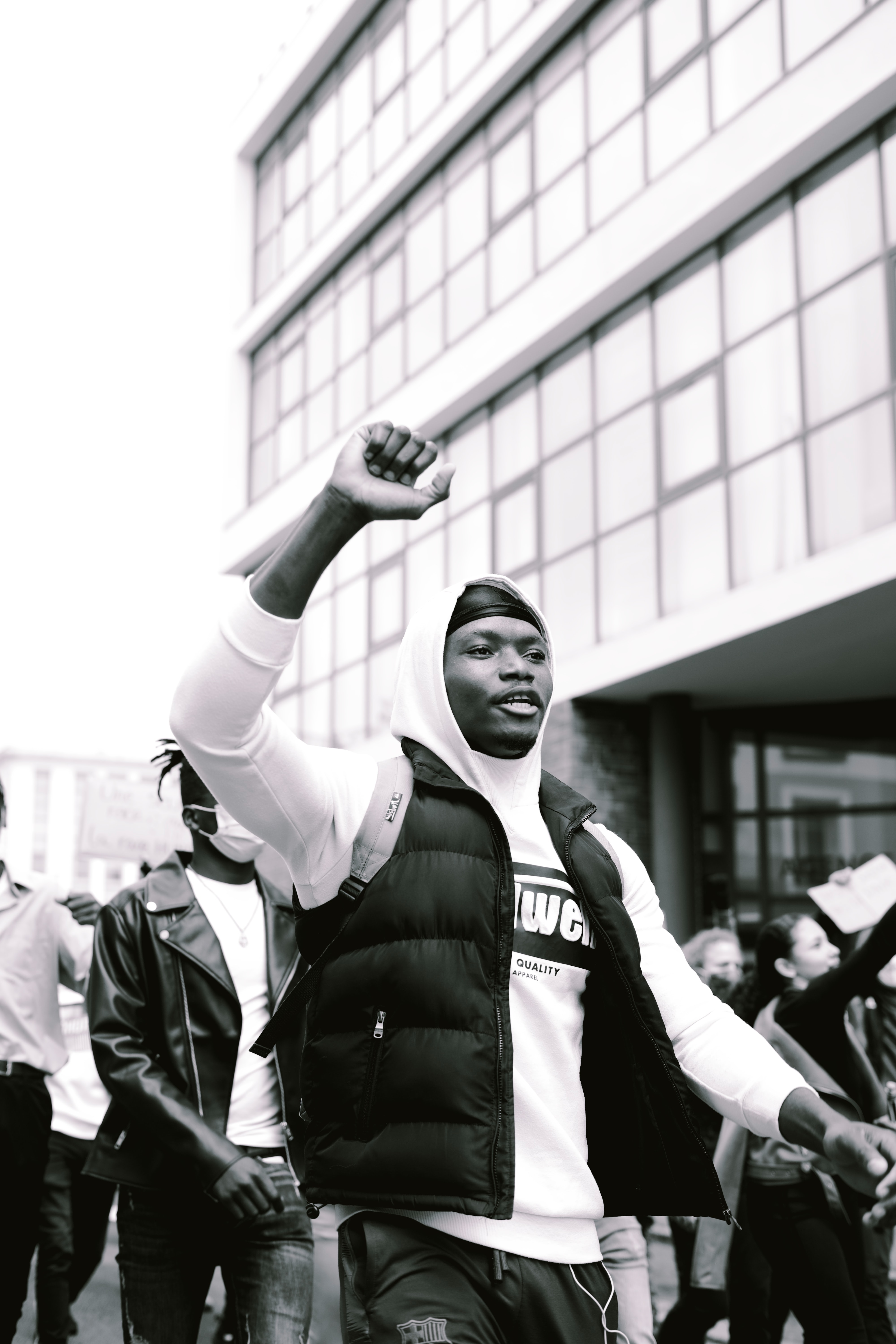 Black person walking in the street with a raised fist